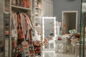 A store interior furnished with white shop shelving displaying clothing