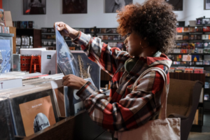 A young lady looking at a record whilst shopping in a music store
